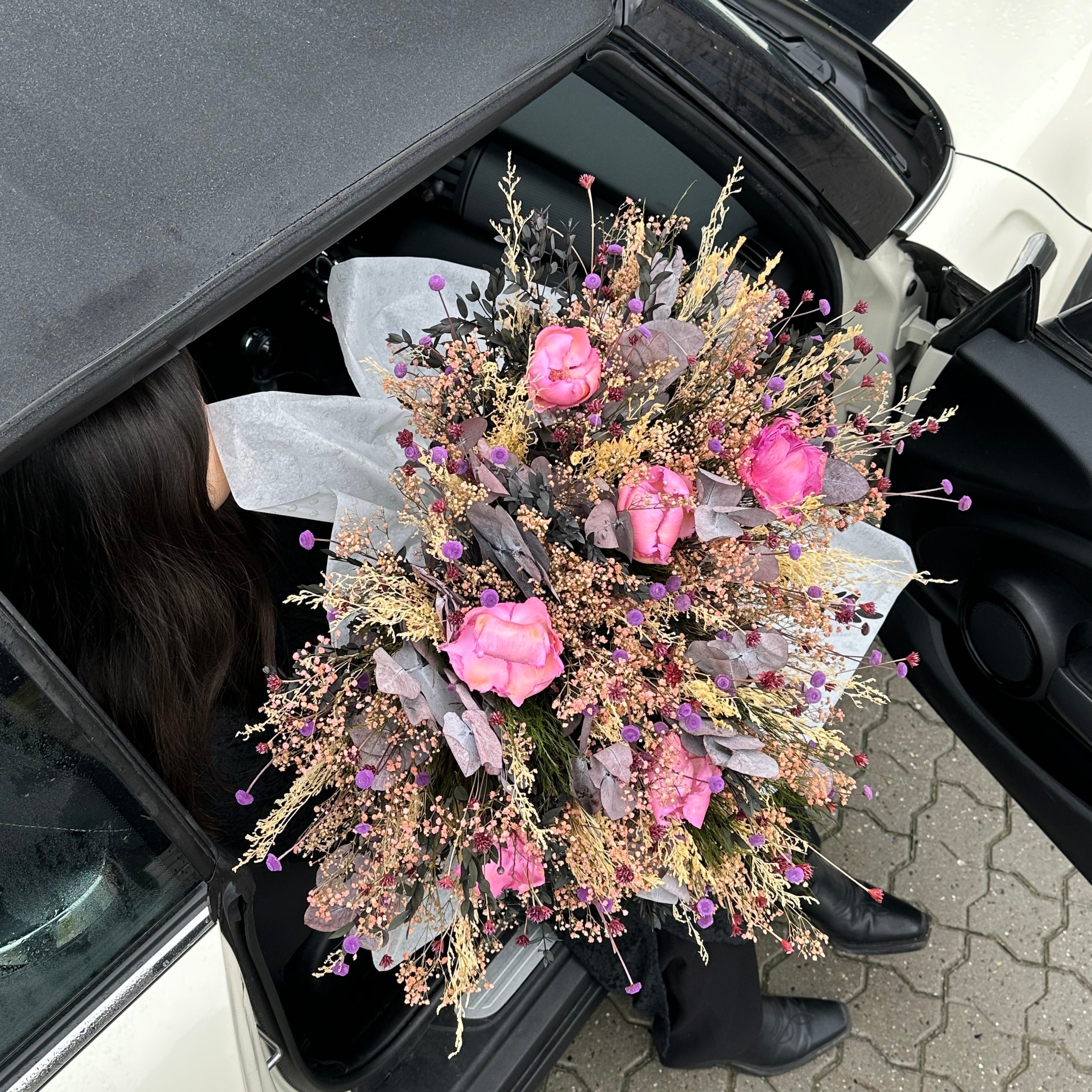 Lyserød buket håndholdt ved bil - fejring valentine