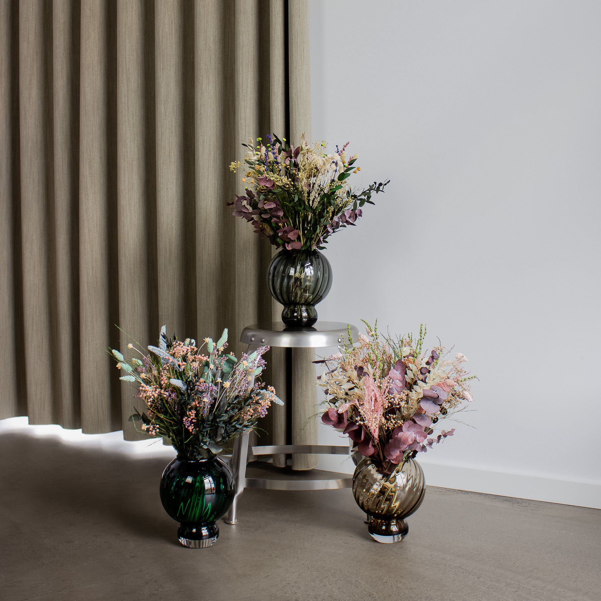 Der står tre forskellige blomsterbuketter i størrelsen Naturligvis.