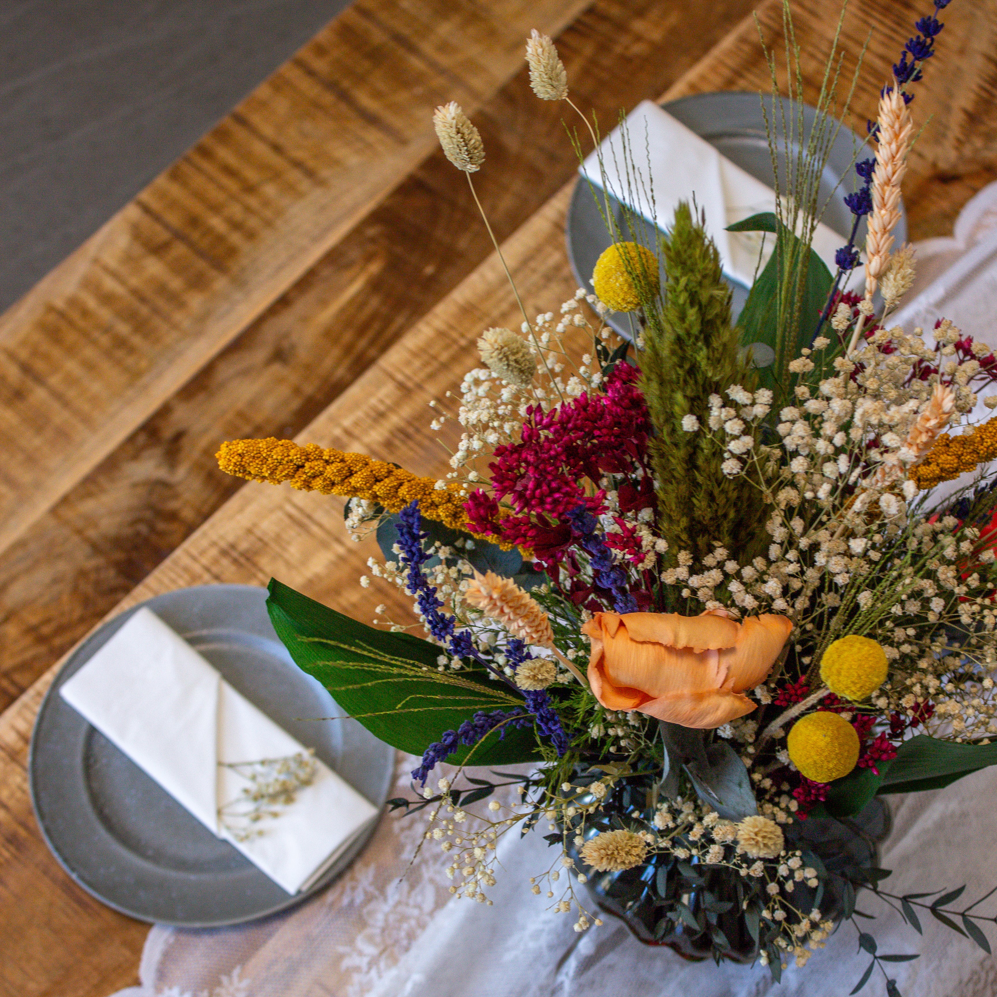 En farverig blomsterbuket står på et dækket bord