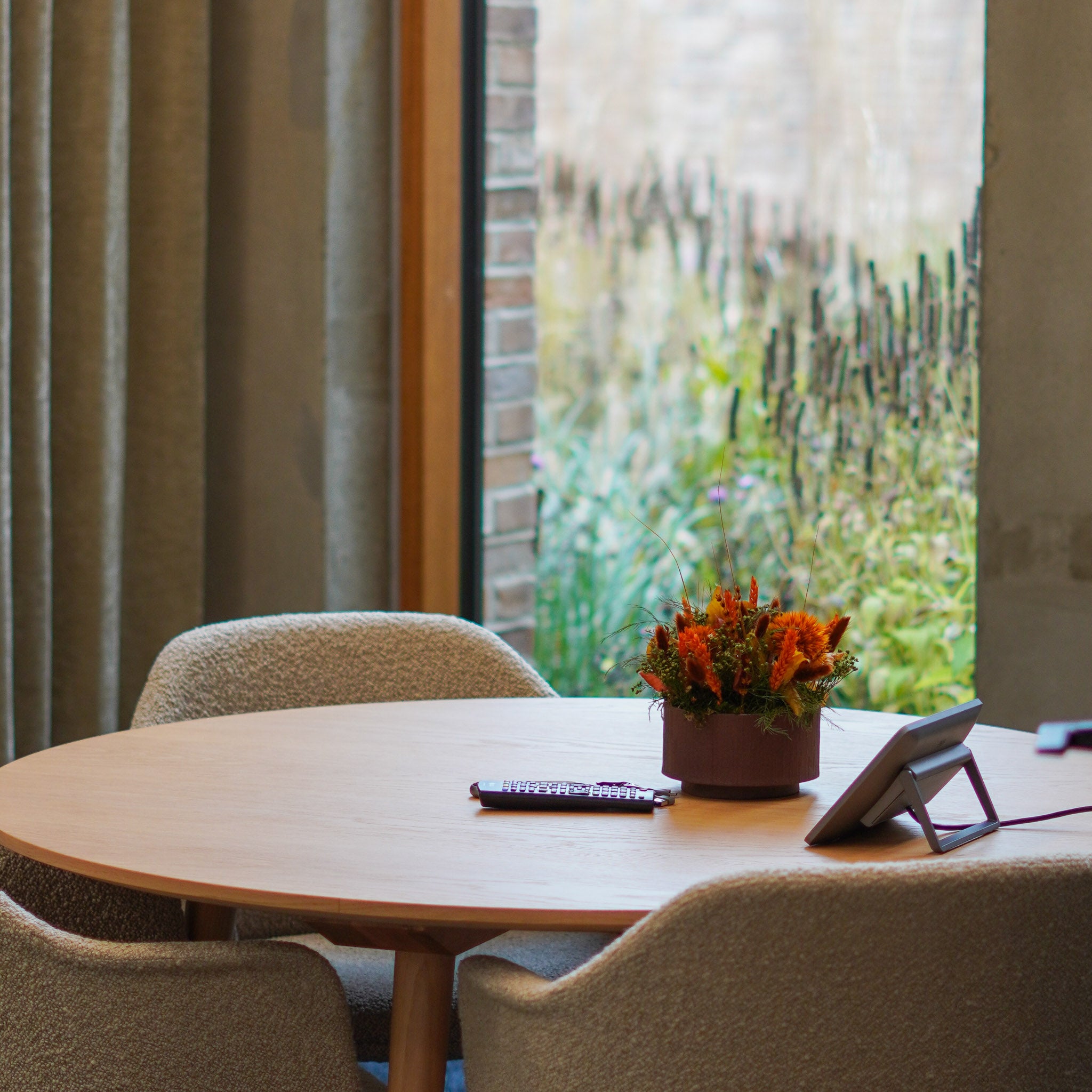 På bordet i et mødelokale står en iøjnefaldende orange blomsterdekoration i en skål.