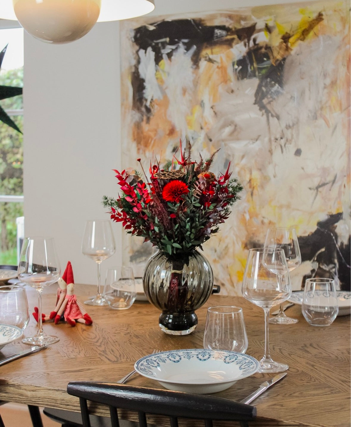 På et julepyntet bord står en rød-grøn buket.