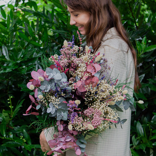 Blomsterbuket med brudeslør og eucalyptus håndhold af kvinde